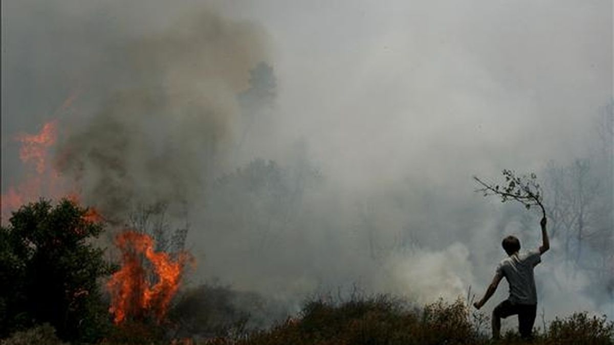 Voluntarios tratan de apagar las llamas del incendio que acecha a la localidad griega de Varnavas, a unos 50 kms de Atenas, (Grecia), ayer sábado, 17 de julio. EFE