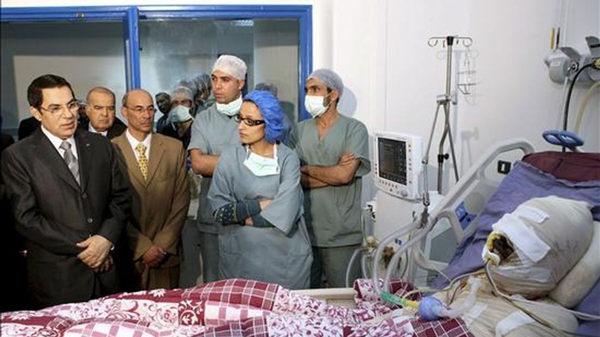 Fotografía distribuída hoy, 5 de enero de 2011, del presidente tunecino Zine El-Abidine Ben Ali (i) visitando a Mohamed Al Bouazzizi (en cama) en el hospital de Ben Arous, Túnez. Al Bouazzizi se prendió fuego el pasado 17 de diciembre, desesperado por su situación como desempleado. EFE