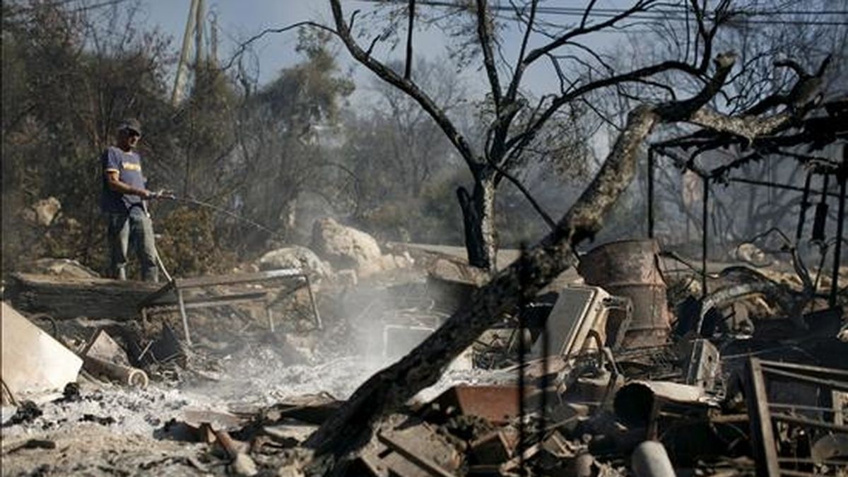 Una residente de la localidad de Ein Hod ayuda en las labores de extinción del incendio declarado en el bosque de Carmel, cerca de Haifa, norte de Israel. EFE