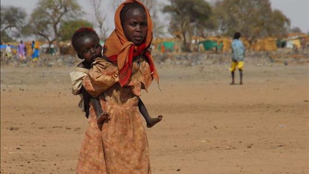 Dos niñas cruzan una tierra reseca en un campo de refugiados, el cual está ocupado por 120.000 personas que han salido de villas aledañas, luego de los enfrentamientos entre el SLA (Ejército de Liberación de Sudán), fuerzas del gobierno y la milicia Janjaweed, en Gereida (Sudán). EFE/Archivo