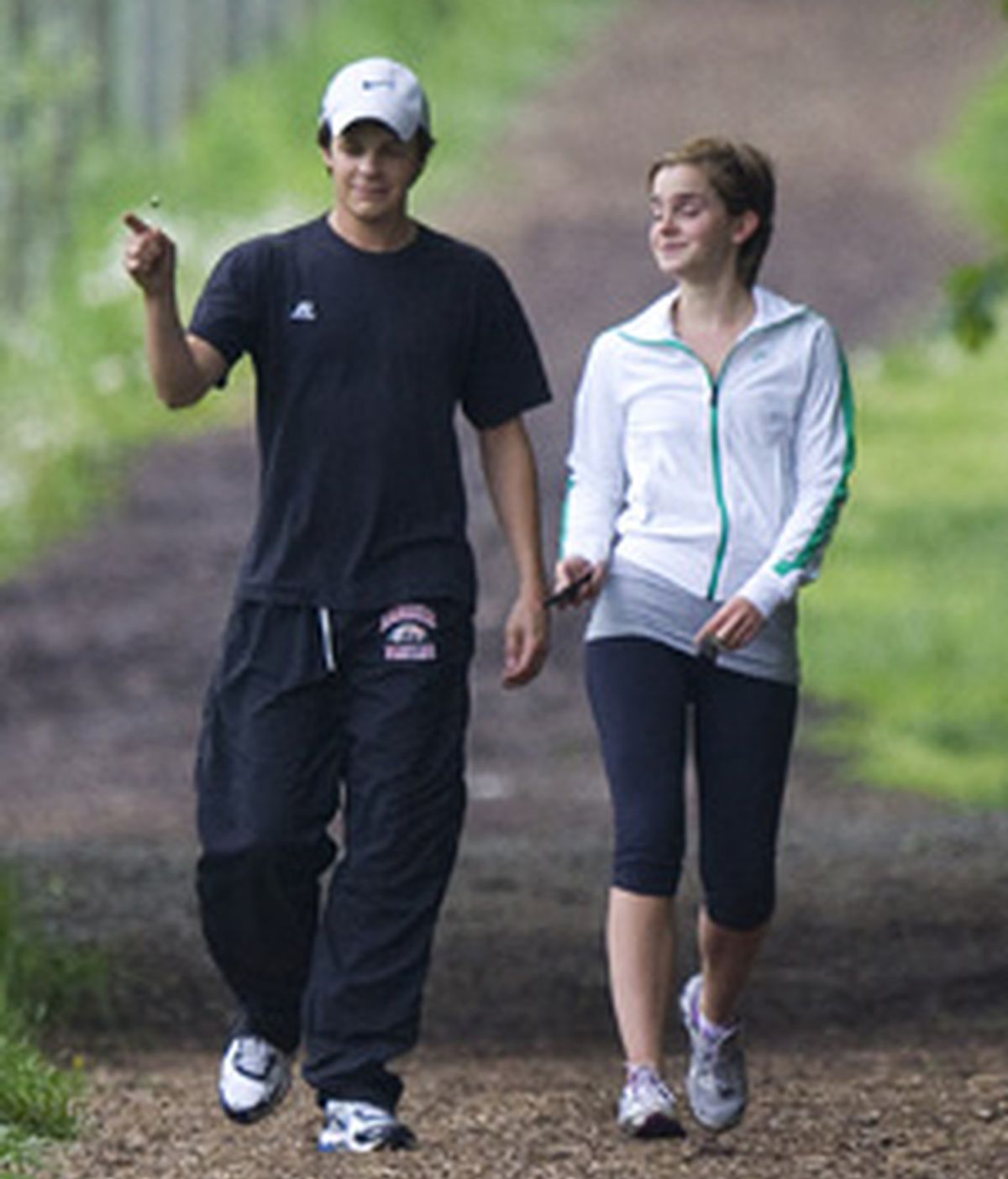 Emma Watson y su compañero Johnny Simons pasean animadamente. Foto: Gtres