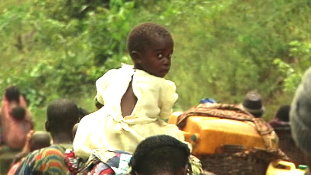 Una niña cansa es transportada a hombros por su padre