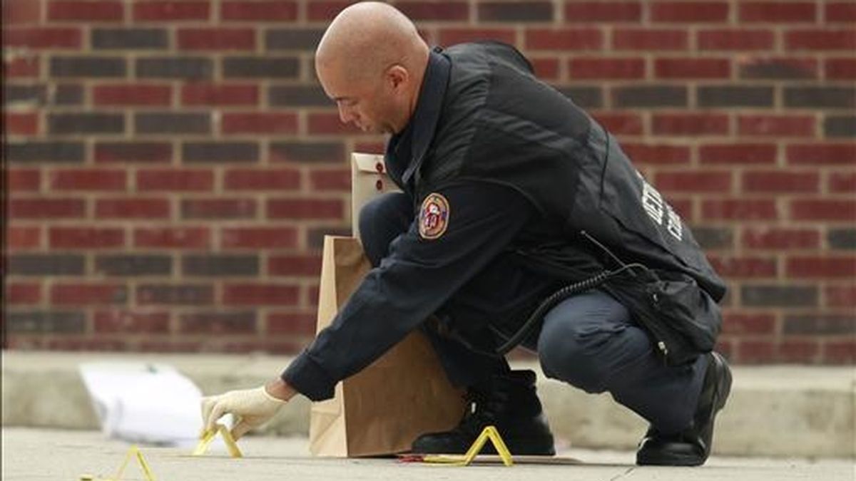 Imagen de este martes de un oficial de la policía de Detroit mientras recoge evidencias en el área donde siete personas recibieron disparos. EFE