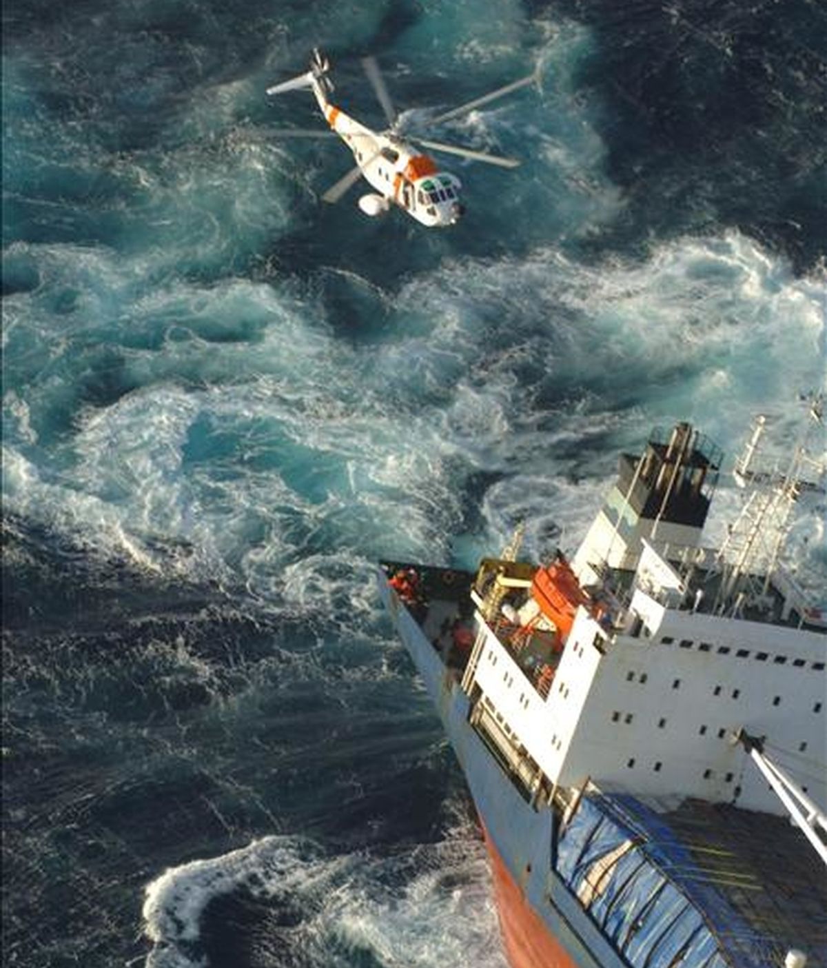 Fotografía facilitada por Salvamento Marítimo de un helicóptero trabajando en las labores de rescate de los 17 tripulantes del mercante "North Spirit". EFE