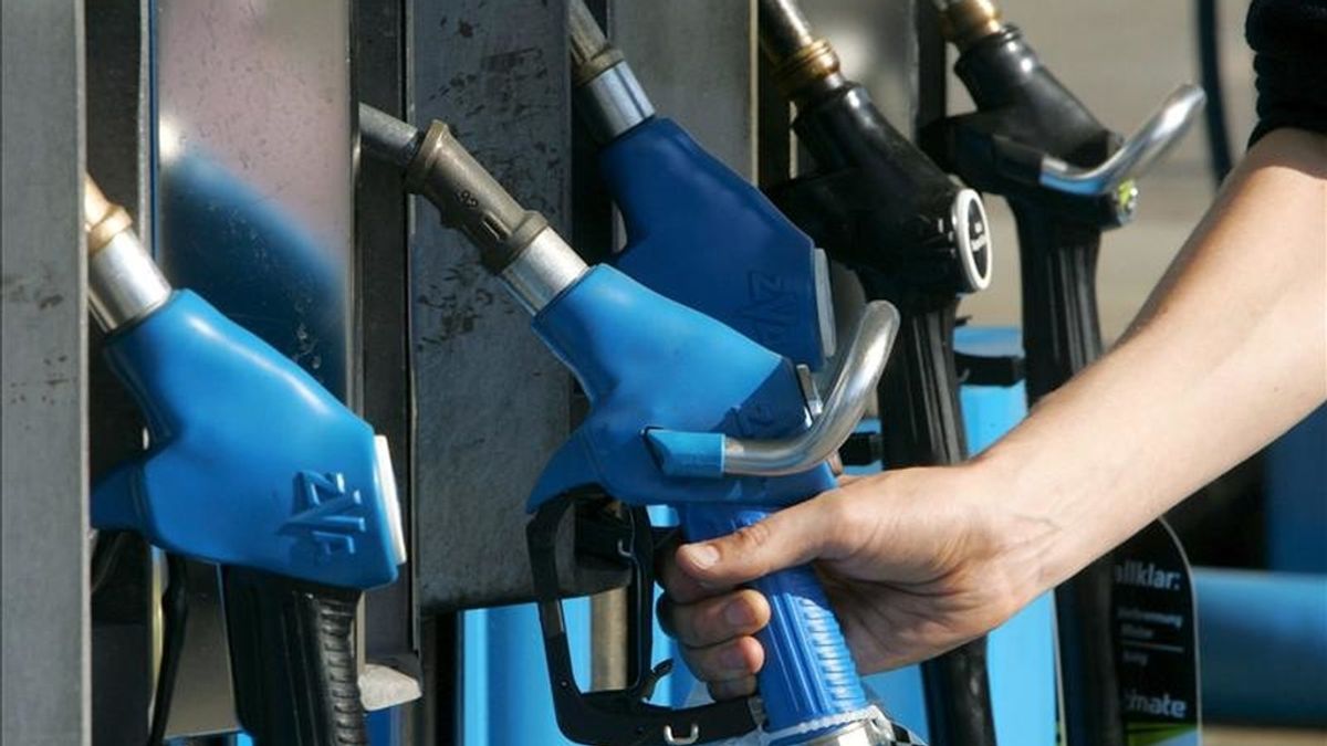 Un hombre toma una manguera de un surtidor de gasolina en una estación de servicio. EFE/Archivo