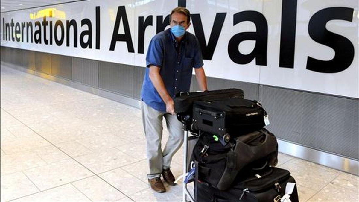 Un pasajero luce una mascarilla a su llegada a la terminal 5 del aeropuerto de Heathrow, en Londres, Reino Unido. EFE/Archivo