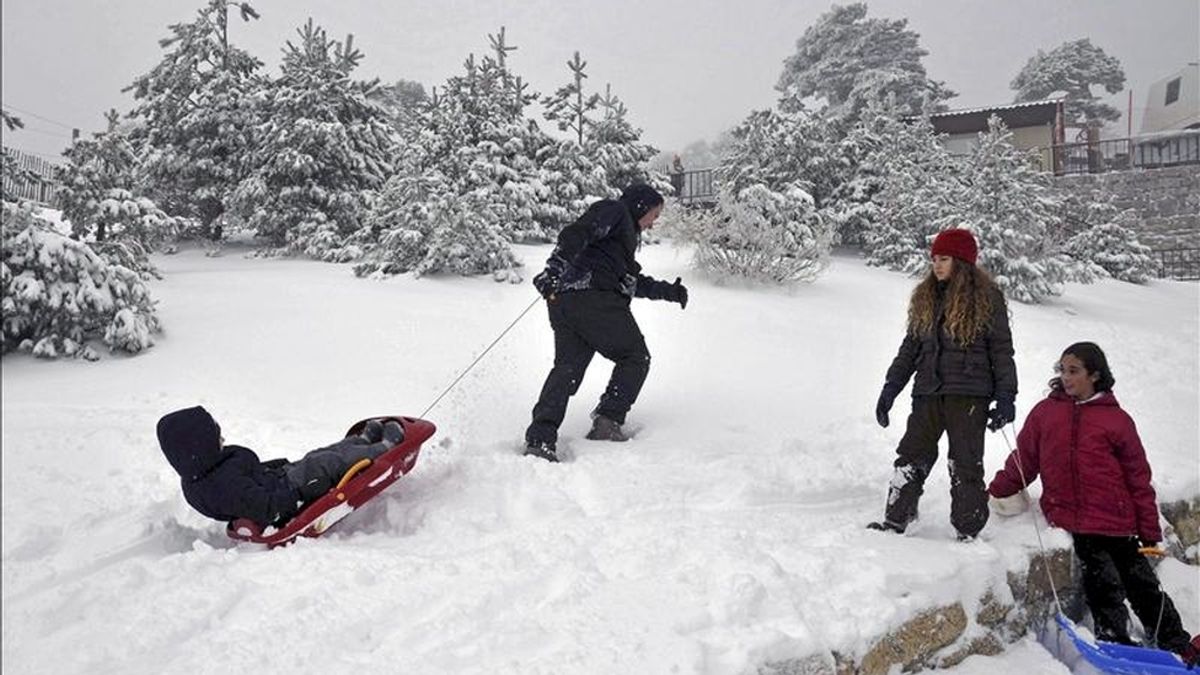 Un hombre juega con sus hijos sobre la nieve. EFE/Archivo