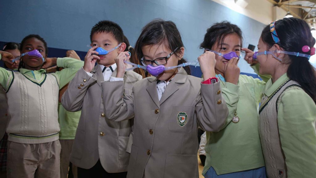 Niños con máscaras nasales por la contaminación en Shangai