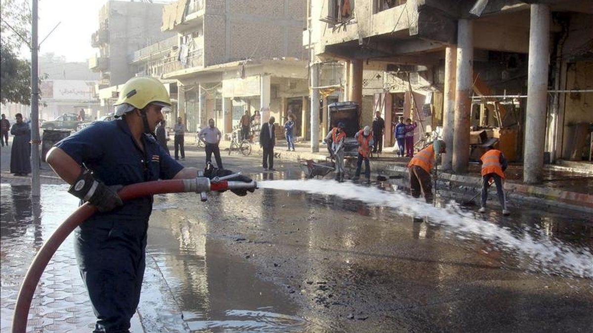 Un bombero iraquí moja el pavimento de la calle en la que se produjo un atentado con coche bomba, en Baquba, al noreste de Bagdad (Irak), el pasado 30 de noviembre. EFE/Archivo