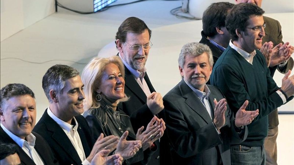 El presidente del PP, Mariano Rajoy (5i) acompañado por el presidente de la Xunta, Alberto Núñez Feijóo (3d), y los candidatos a las principales ciudades gallegas, saludan a los militantes y simpatizantes al comienzo del acto de clausura de la convención que celebra el partido popular este fin de semana en Santiago de Compostela. EFE