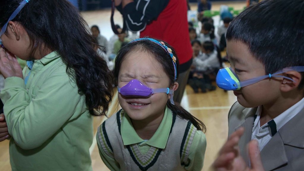 Niños con máscaras nasales por la contaminación en Shangai
