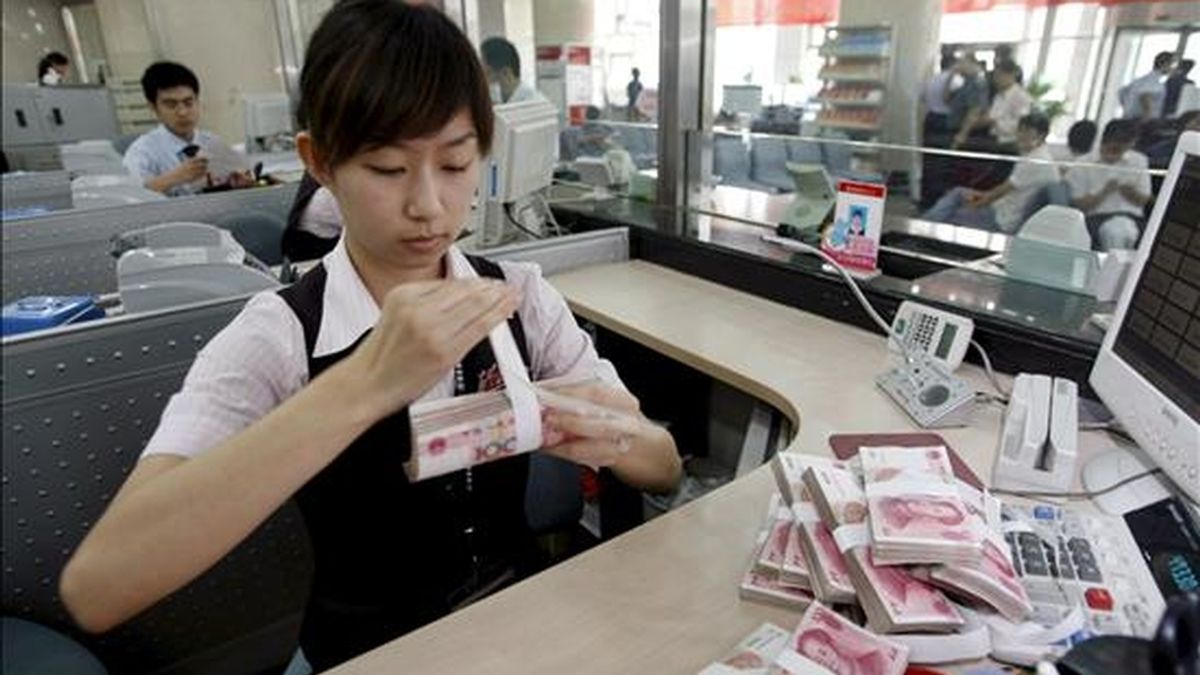 Una empleada del Banco Comercial de China cuenta billetes de 100 yuan en una sucursal de Pekín. EFE/Archivo