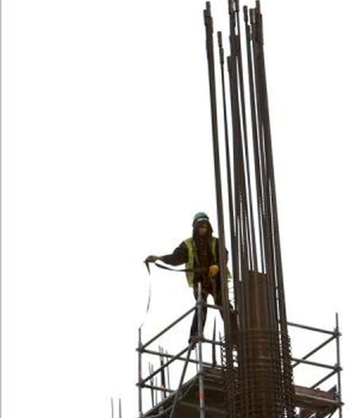 Un trabajador de la construcción intenta asegurarse con su arnés en una obra. EFE/Archivo