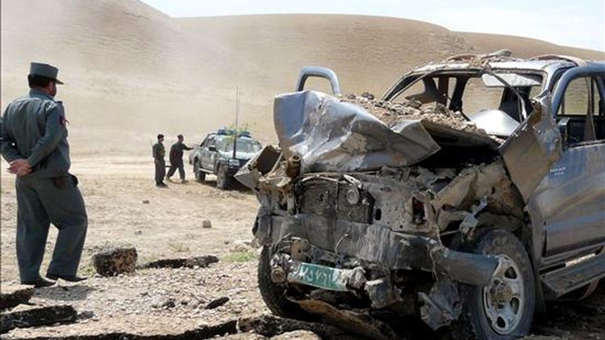 Un policía afgano pasa junto a un coche de la organización Mercy Corps dañado en un atentado en Kunduz, Afganistán, el pasado jueves. EFE