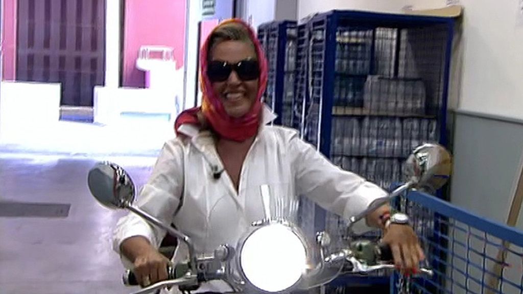 Cubierta con un pañuelo y sobre dos ruedas, la colaboradora vuelve de vacaciones