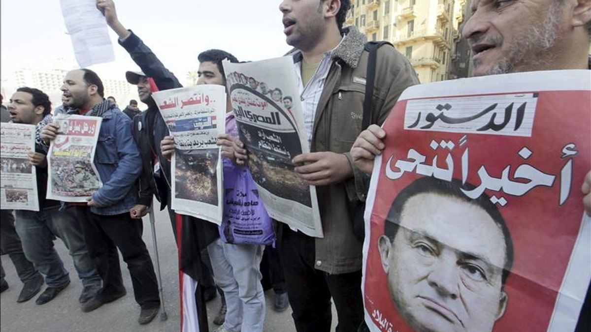 Varios ciudadanos muestran periódicos que en portada informan sobre la renuncia del presidente egipcio, Hosni Mubarak, en la plaza Tahrir un día después de la renuncia del mandatario hoy, 12 de febrero de 2011 en El Cairo (Egipto). En el periódico de la derecha se puede leer "Al final dimitió". EFE