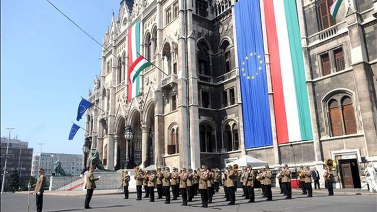 La banda de viento del Ejército húngaro toca frente al Parlamento, en Budapest (Hungría), durante la ceremonia de izado de la bandera para conmemorar el vigésimo aniversario de la caída del "Telón de Acero", el 27 de junio de 2009. El desmantelamiento del Telón supuso la apertura de la frontera entre la Hungría comunista y Austria. EFE