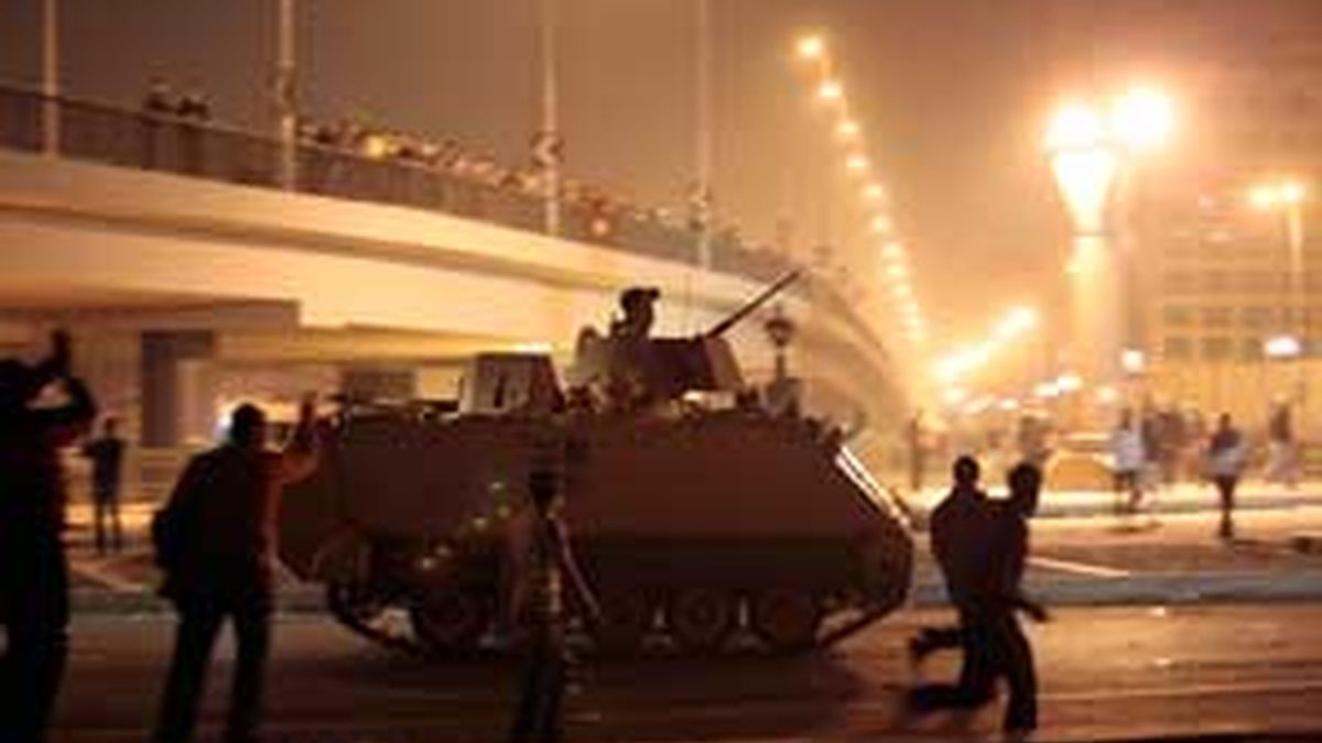 Manifestantes contrarios al gobierno egipcio, junto a una tanqueta del Ejército cerca de la Plaza Tahrir de El Cairo. Foto. AP.