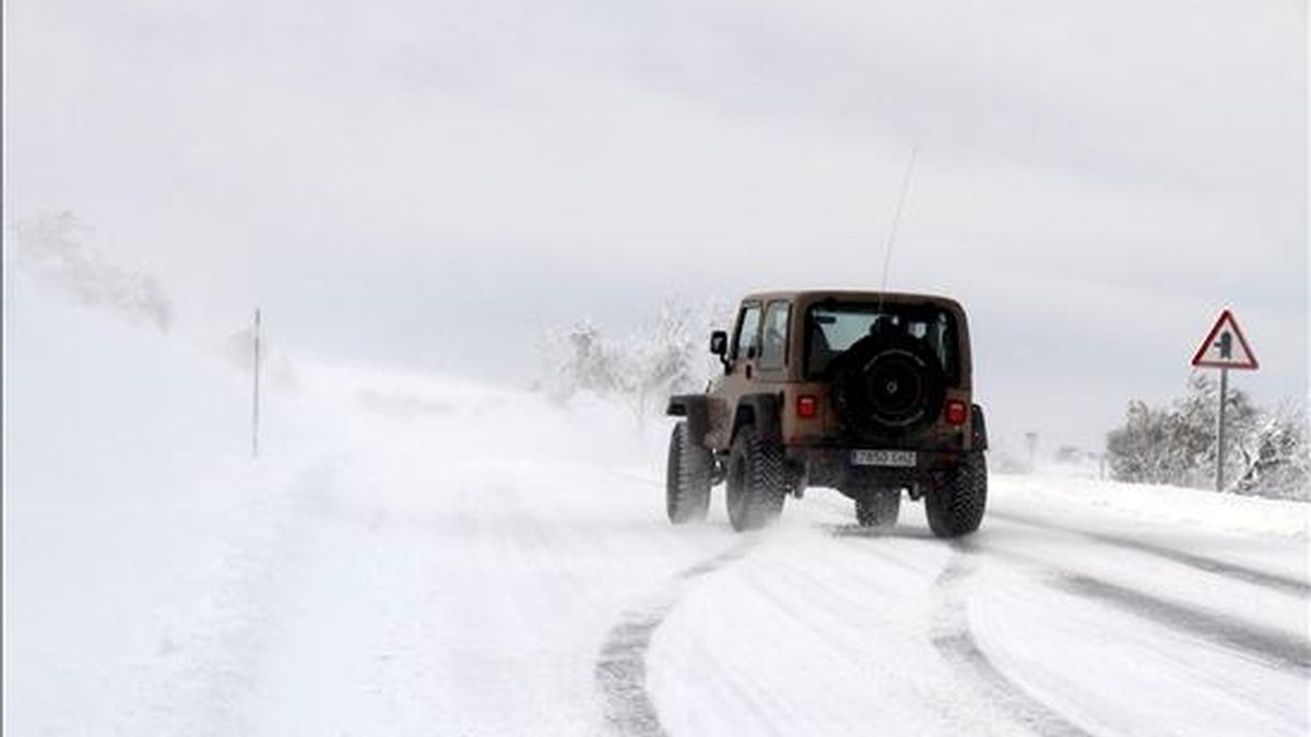 Un coche a su paso por O Cebreiro (Galicia), intenta circular por la carretera LU-633, en dirección a Sarria, a pesar de la nieve que cubre toda la vía. EFE