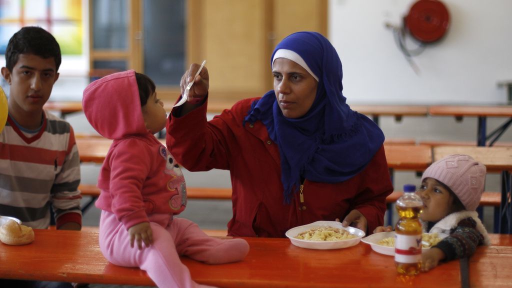 Una refugiada da de comer a sus hijos en Alemania