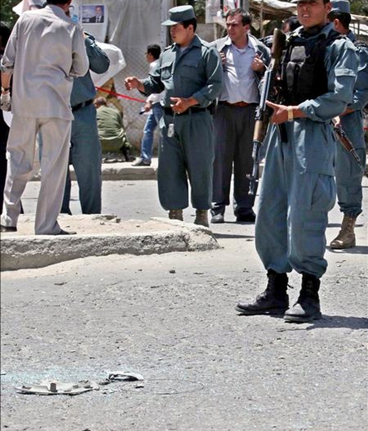 Policías afganos controlan el lugar donde ha tenido lugar un ataque suicida contra un convoy extranjero que circulaba hoy por Kabul. EFE
