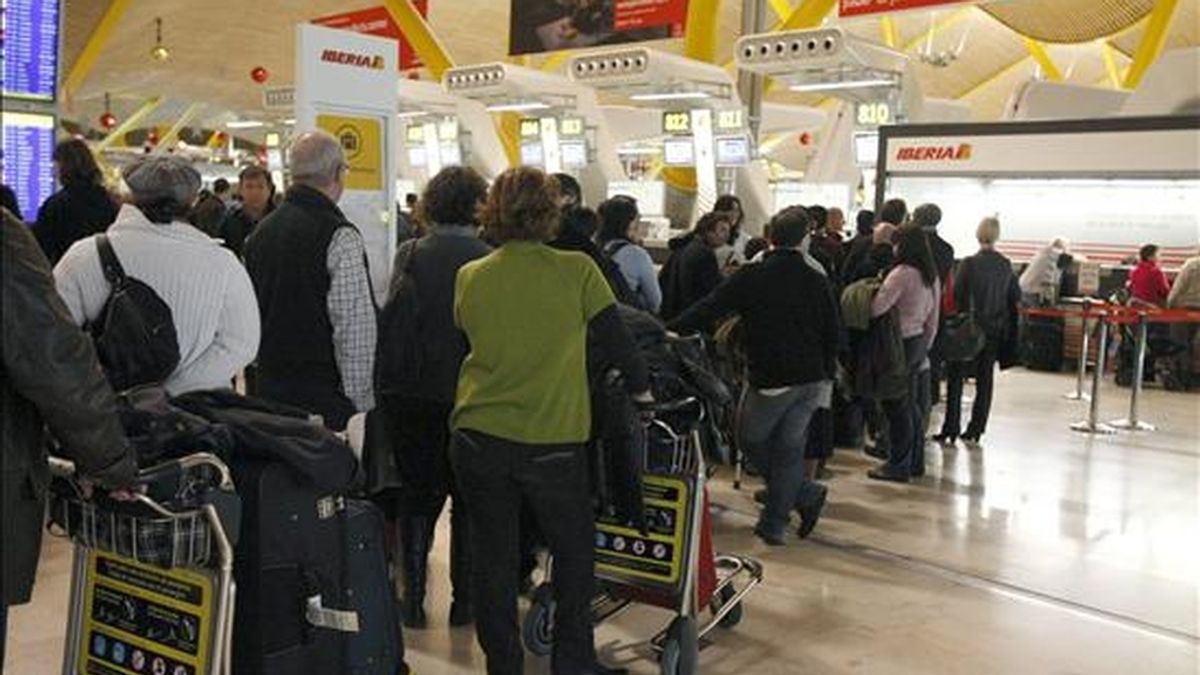 Decenas de turistas hacen cola en los mostradores de una compañía aérea esta tarde en el aeropuerto de Madrid-Barajas con motivo del inicio del puente de la Constitución. EFE