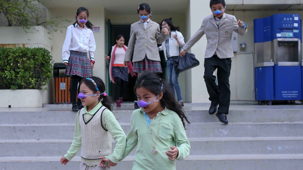 Niños con máscaras nasales por la contaminación en Shangai