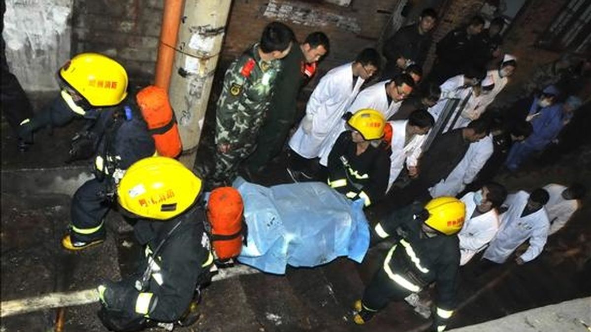 Miembros de los equipos de rescata trasladan el cuerpo sin vida de una de las víctimas de una explosión en un cibercafé en Kaili (China) hoy, 5 de diciembre de 2010. La explosión causó al menos seis muertos y 37 heridos, informó hoy la agencia oficial de noticias Xinhua. EFE