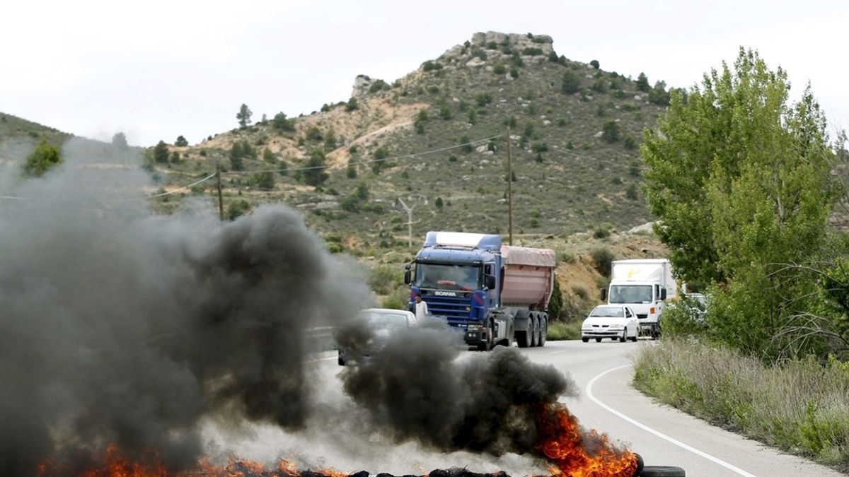 Una barrera compuesta por neumáticos incendiados, colocadas por un grupo de mineros para bloquear el suministro de carbón de importación a la Central térmica de Endesa en Andorra (Teruel), impide el paso de vehículos en las carretera entre Andorra y Ariño.