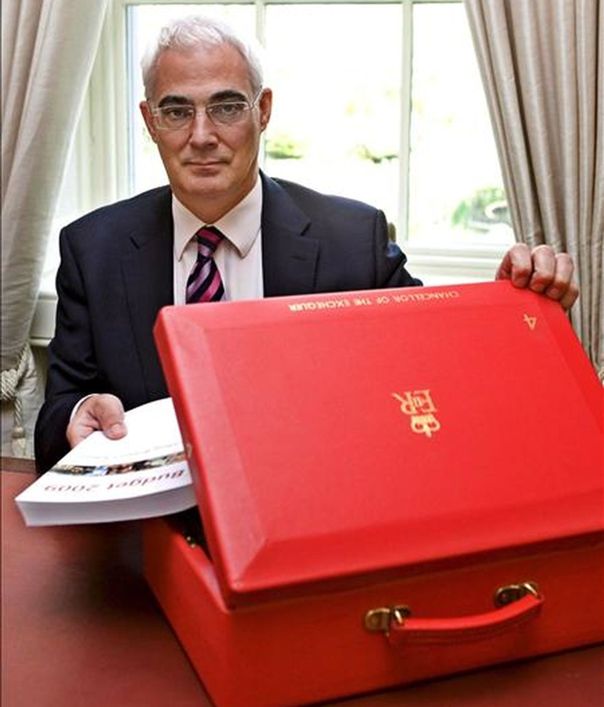 El ministro británico de Economía, Alistair Darling, introduce en su cartera el ejemplar con los presupuestos del Estado, en su oficina en el número 11 de Downing Street, Londres (Reino Unido). EFE/Archivo