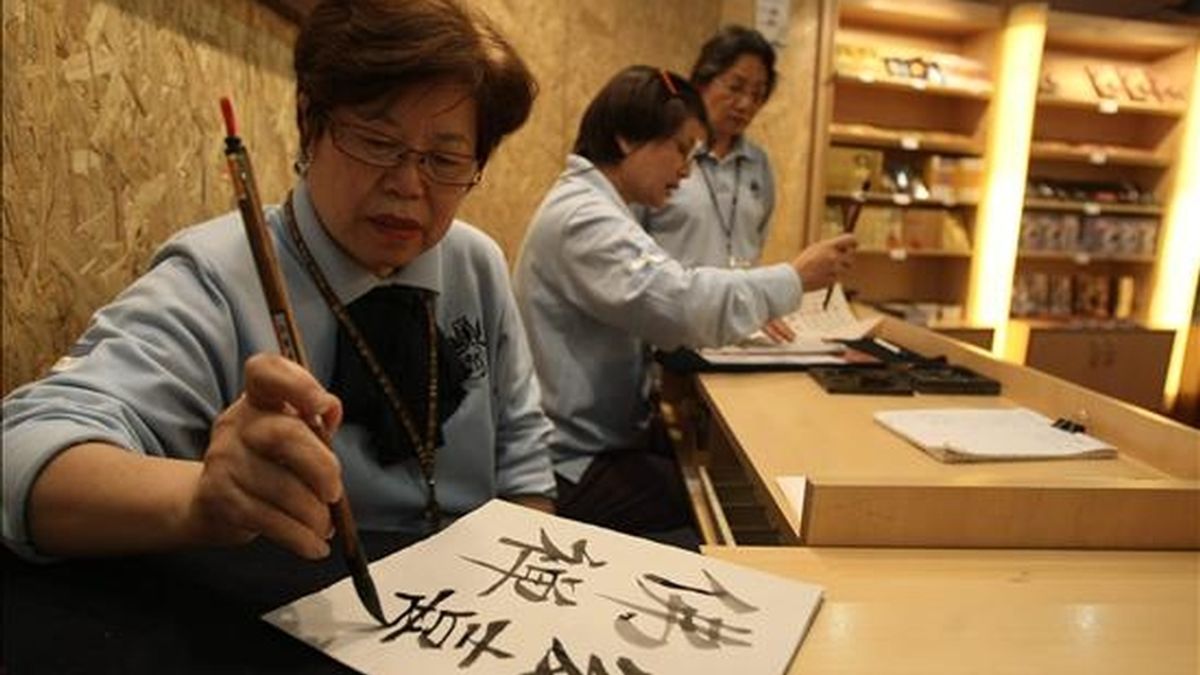 Una mujer escribe ideogramas en idioma Han. EFE