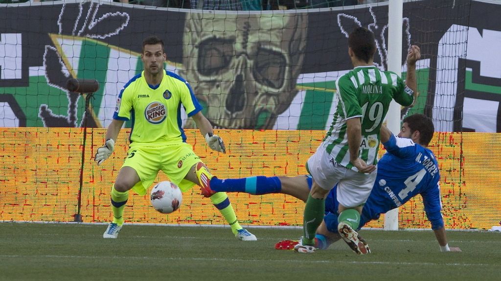 El delantero del Real Betis Jorge Molina chuta a portería ante el portero y el defensa del Getafe CF Miguel Ángel Moyá y Miguel Torres