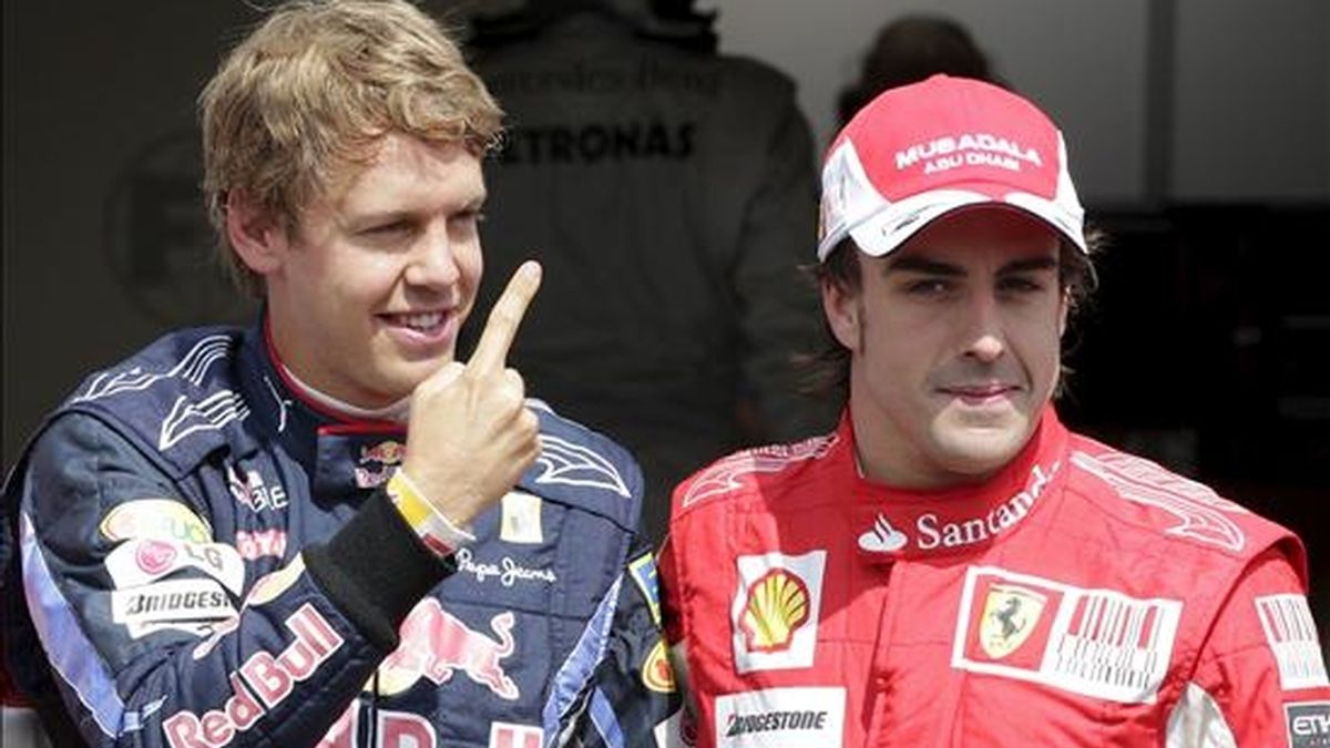 El piloto alemán Sebastian Vettel (i), de Red Bull Racing, y el español Fernando Alonso (d), de Ferrari, celebran tras la sesión de clasificación del Gran Premio de Alemania realizada en el circuito de Hockenheim, hoy. EFE