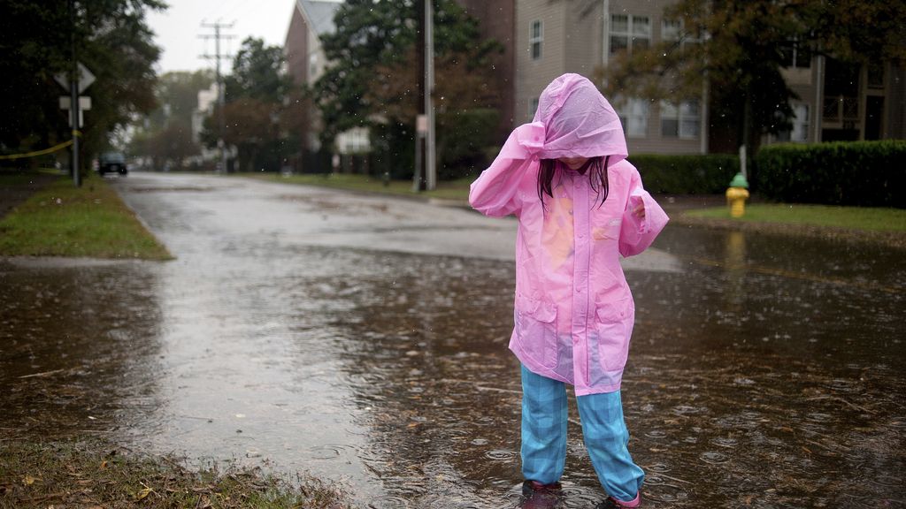 Una niña juega en la calle durante el paso del huracán