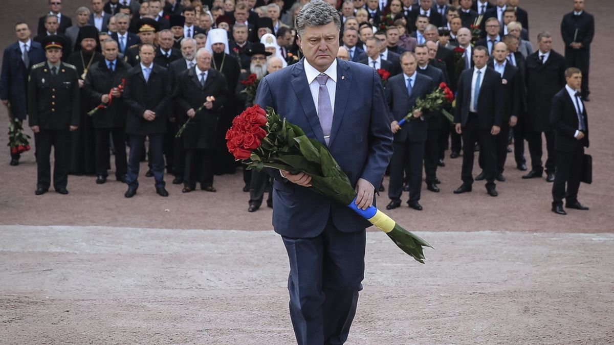 El presidente ucraniano, Petro Poroshenko (c), deposita flores en el monumento de las víctimas de la masacre Nazi en Babi Yar, en Kiev