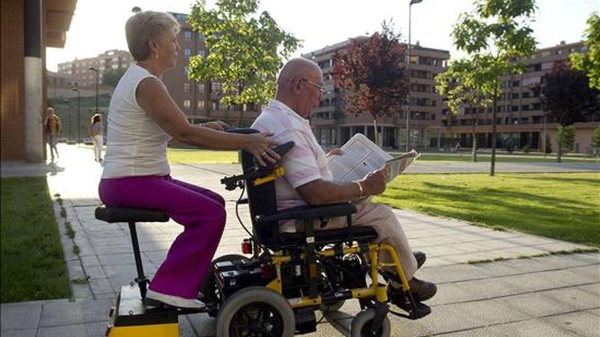 El inventor zamorano Carmelo Ferrero y su mujer Mari Paz Prieto pasean por las calles de Zamora con el remolque con asiento para silla de ruedas eléctrica que han comenzado a comercializar. EFE