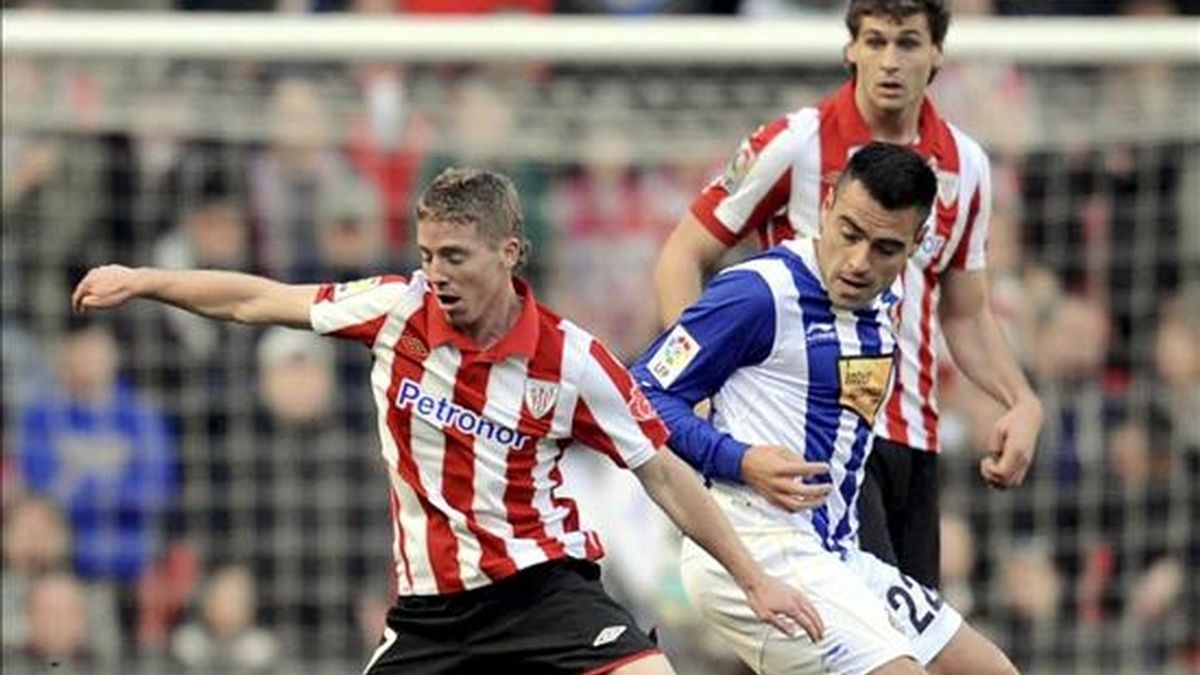 El delantero del Athletic de Bilbao, Iker Muniain (i), defiende un balón frente al centrocampista argentino del Espanyol, Aldo Duscher (d), durante el partido correspondiente a la decimoquinta jornada de Liga en Primera División en el estadio San Mamés de Bilbao.EFE