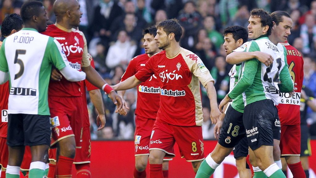 El delantero uruguayo del Racing de Santander Christian Stuani es sujetado por su compañero Bernardo Espinosa tras tener un enfrentamiento con el defensa francés del Sporting de Gijón Gregory Arnolin