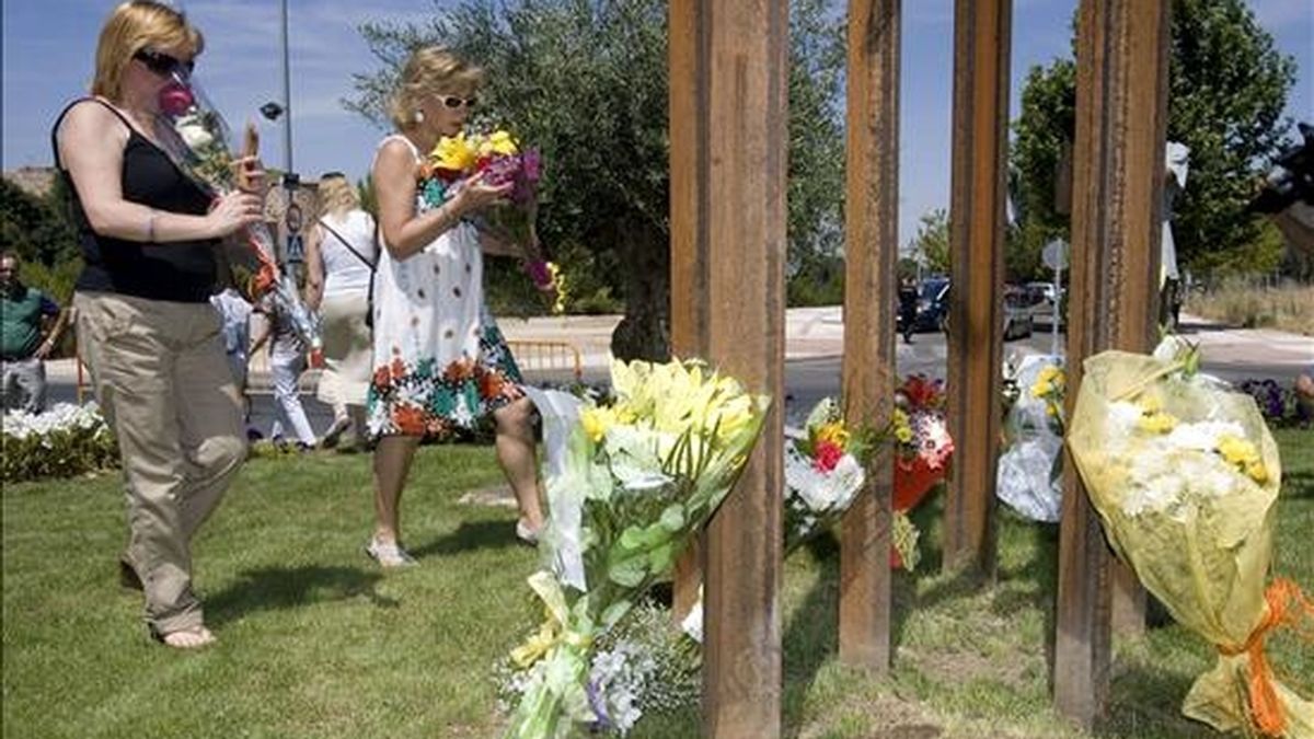 Dos familiares de algunas de las once víctimas del incendio de la Riba de Saelices (Guadalajara) depositan flores en el monumento inaugurado en su recuerdo al cumplirse el quinto aniversario del suceso. EFE