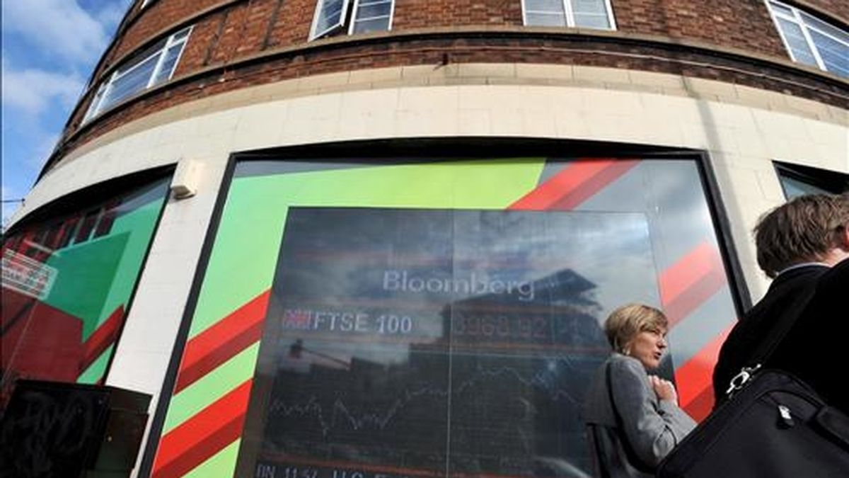 Una mujer pasa por delante de un panel electrónico en el que se muestran los valores de la Bolsa, en Londres (Reino Unido). EFE/Archivo