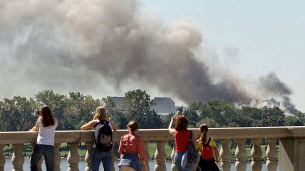 Turistas observan el humo desde un puente de la ciudad