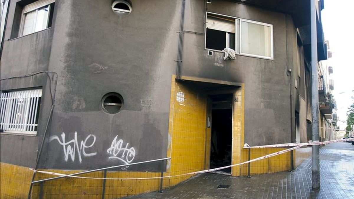 Un cordón policial a la entrada de un edificio de viviendas ubicado en el número 41 de la calle Mas de L'Hospitalet de Llobregat, donde se ha declarado hoy un incendio en el que han resultado heridas siete personas, dos de ellas de gravedad. EFE