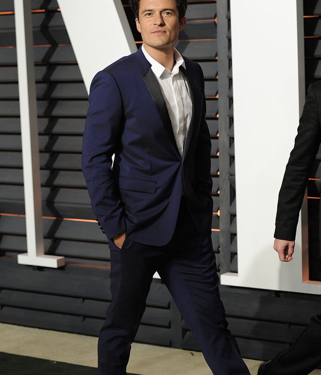 Orlando Bloom con traje azul marino y camisa blanca
