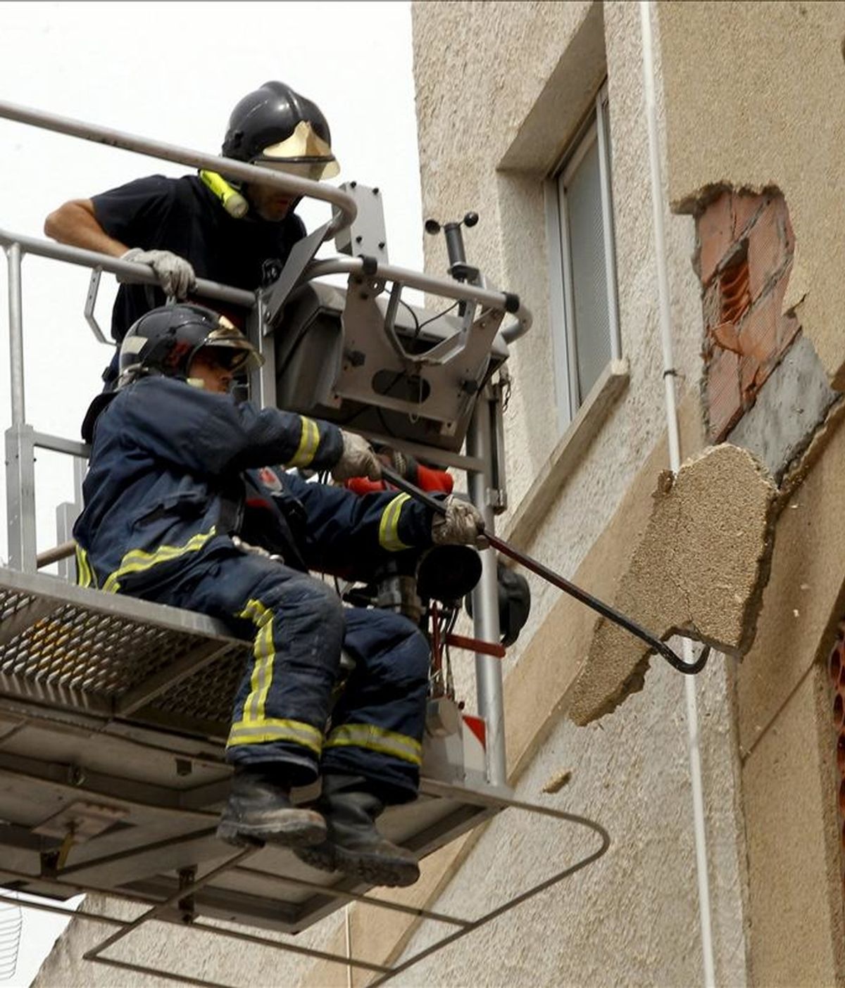 Dos bomberos trabajando en un edificio en la ciudad de Lorca, que trata de recuperar la normalidad después de los dos terremotos que asolaron el pasado miércoles la ciudad. EFE