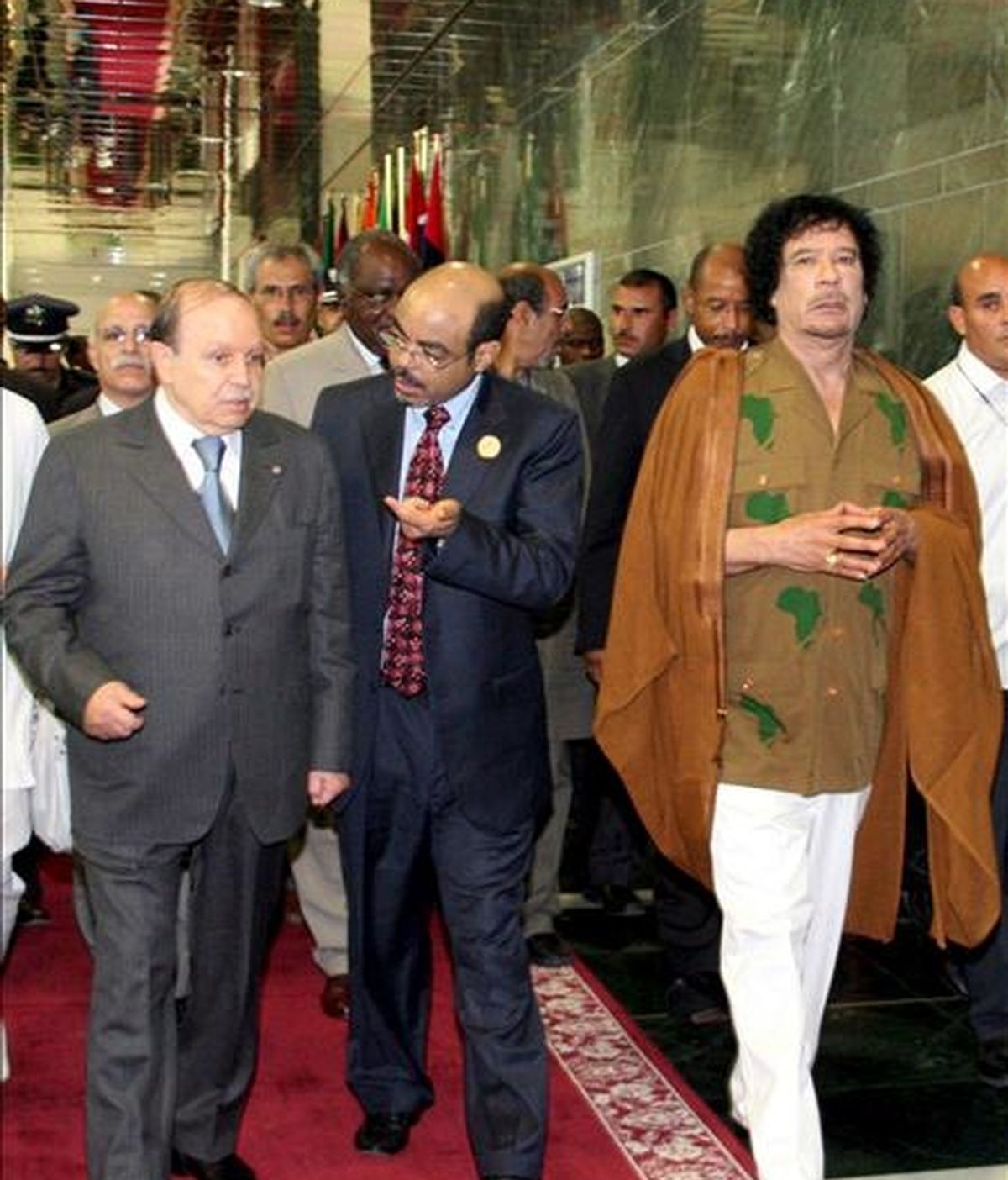 El líder libio y presidente de la Unión Africana, Muamar Gadafi (d), y el presidente de Argelia, Abdelaziz Bouteflika (i), a su llegada ayer a la vigésimo primera cumbre del Comité de Dirección de la Nueva Asociación para el Desarrollo de África (NEPAD), que se celebró en Sirte, Libia. EFE