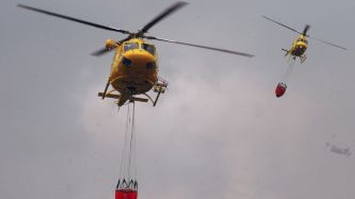 Dos helicópteros durante las labores de extinción del incendio que fue declarado en la sierra de Atamaría (Cartagena). EFE
