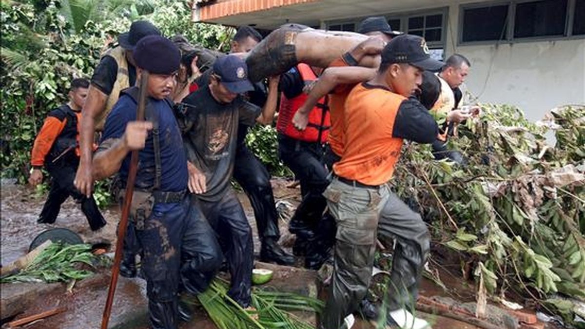Miembros de los equipos de rescate evacuan el cadáver de un hombre muerto en una riada originada por la rotura de una presa en Yakarta, Indonesia, hoy viernes 27 de marzo. EFE