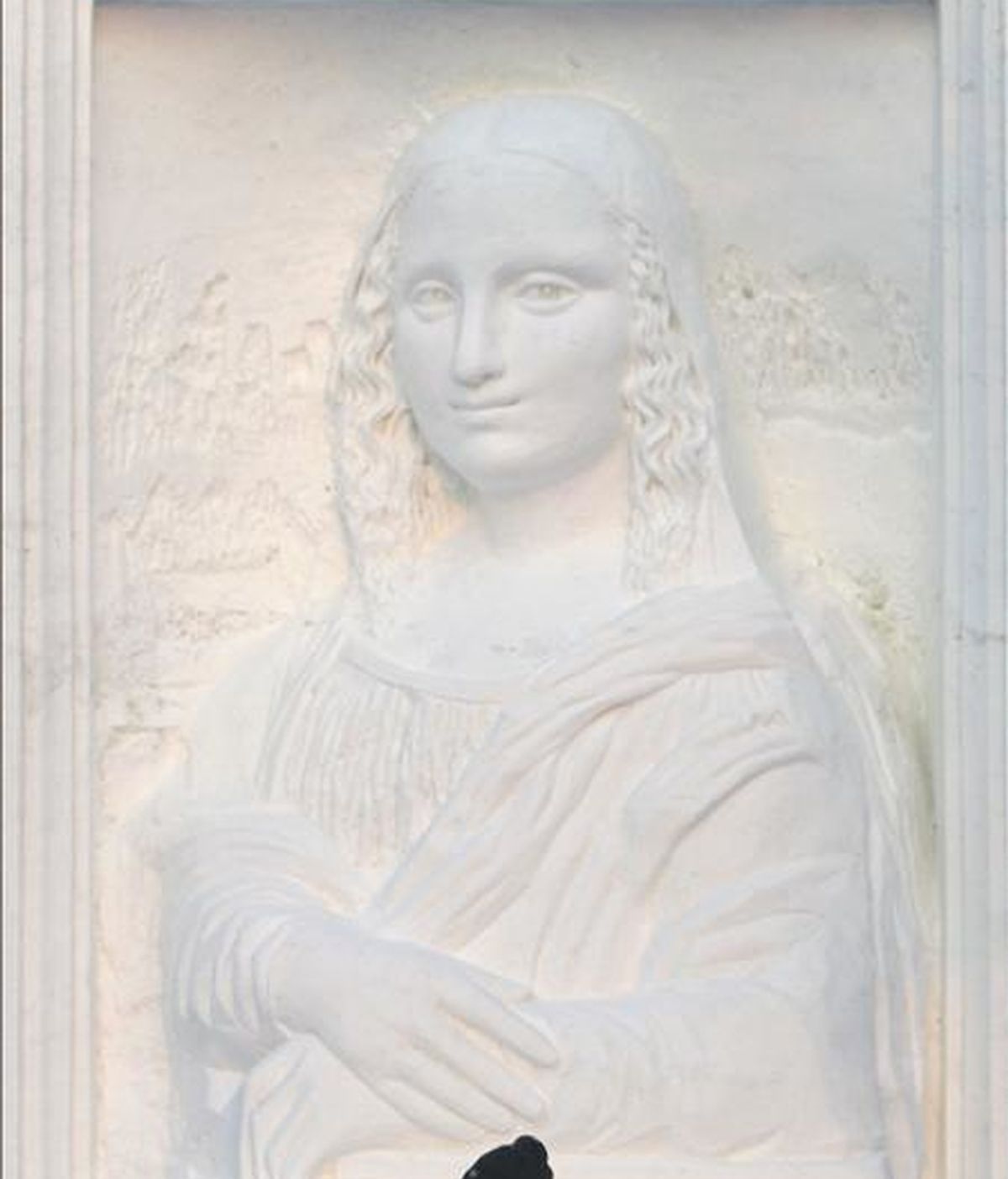 Un hombre pasa frente a una réplica de la "Mona Lisa" de Leonardo da Vinci, una de las gigantescas estatuas de nieve y agua helada que anualmente se esculpen para ser las estrellas del Festival de la Nieve y el Hielo, una fiesta que comienza hoy y durará varios meses, en la ciudad de Harbin, donde los termómetros pueden llegar hasta los 40 grados bajo cero, en el extremo norte de China. EFE