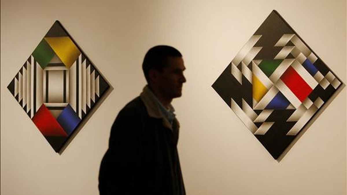 Fotografía en la que se observa a un hombre caminando junto a dos obras del pintor colombiano Ómar Rayo en Bogotá (Colombia). Rayo dijo en entrevista concedida a EFE que tras "escapar de la muerte" ahora pinta "con todo el abecedario". EFE