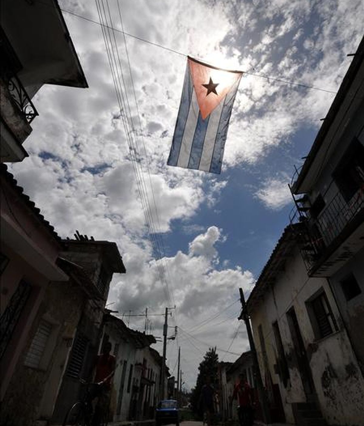 Varias personas caminan por una calle adornada con banderas cubanas en Santa Clara, un día antes de celebrase en esta ciudad el acto central por el Día de la Rebeldía Nacional. EFE